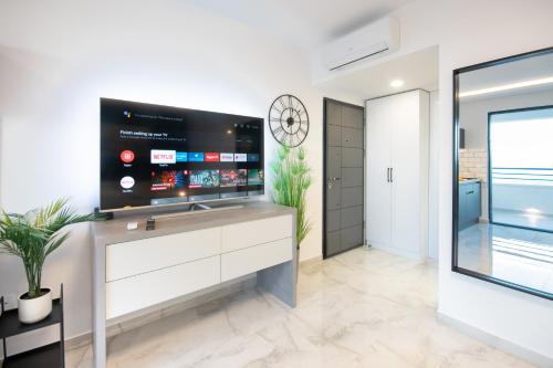 a living room with a large tv on a wall at SunnySide luxury suites with free parking and swimming pool in Brela