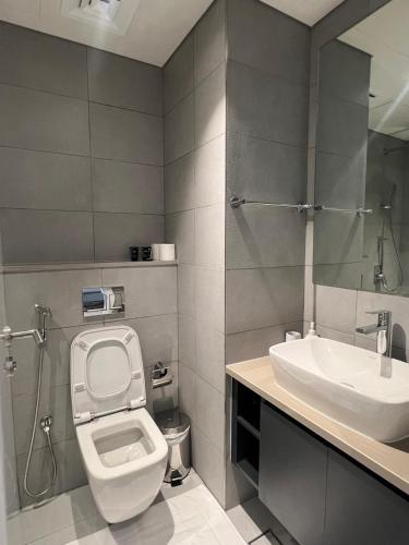 La salle de bains est pourvue de toilettes et d'un lavabo. dans l'établissement Garden & Pool Access Studio, à Charjah