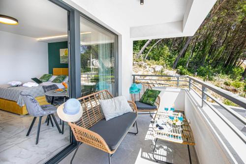 a room with a balcony with a bed and a table at SunnySide luxury suites with free parking and swimming pool in Brela