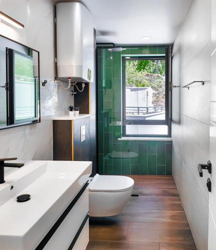 a bathroom with a toilet and a sink and a window at SunnySide luxury suites with free parking and swimming pool in Brela