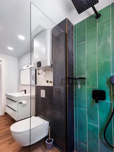 a bathroom with a toilet and a glass shower at SunnySide luxury suites with free parking and swimming pool in Brela