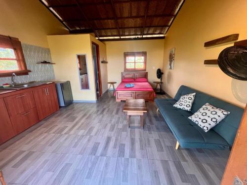 ein Wohnzimmer mit einem Sofa und einem Bett in der Unterkunft Juanchos House Hostel Tayrona in Los Naranjos
