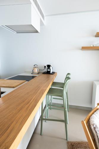 a kitchen with a wooden counter and a green chair at Panoramic Seaview Penthouse The Wave in Fuengirola