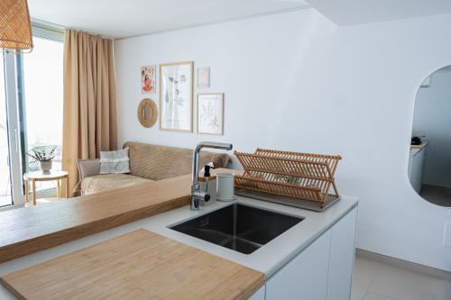a kitchen with a sink and a living room at Panoramic Seaview Penthouse The Wave in Fuengirola
