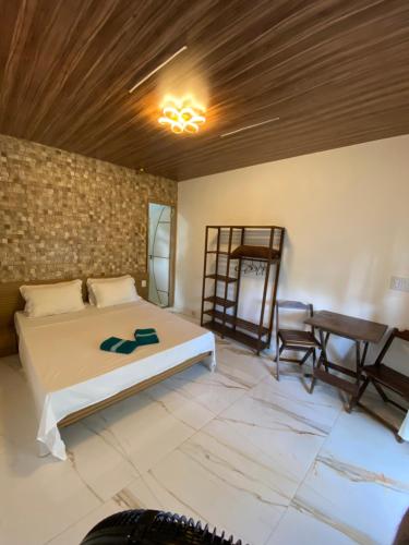 1 dormitorio con cama y techo de madera en • Suíte Palmas • À Beira-Mar - Ilha Grande RJ®, en Praia de Palmas