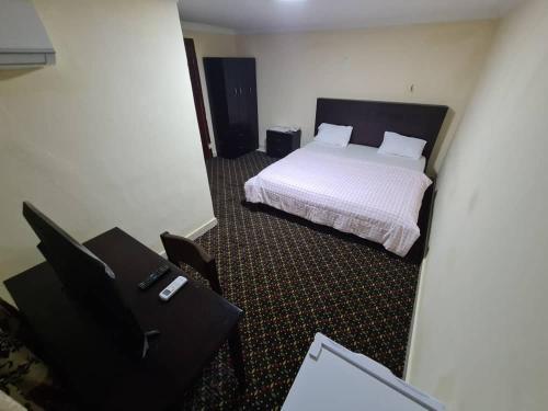 a bedroom with a bed and a desk with a chair at Kings Empire Hotel in Freetown