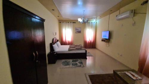 a living room with a bed and a tv in a room at Kings Empire Hotel in Freetown