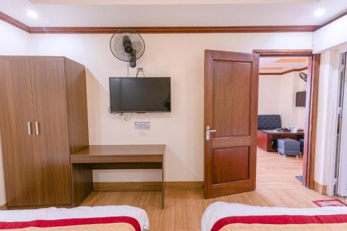 a room with a desk and a tv on the wall at Huong Duong Hotel Lao Cai in Lao Cai