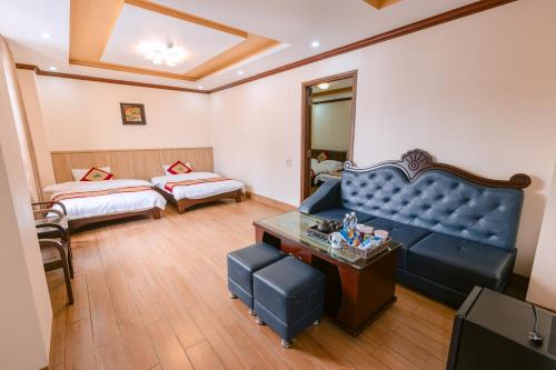 a living room with a blue couch and a bed at Huong Duong Hotel Lao Cai in Lao Cai