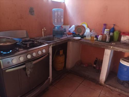 a kitchen with a stove and a counter with a sink at Hospedaje Marlenis in Managua