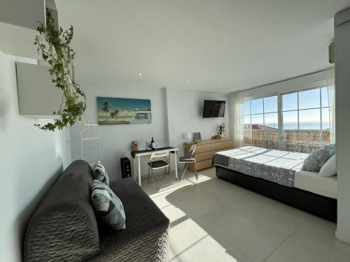 1 dormitorio con cama y escritorio en Peaceful studio with amazing sea views and free parking en Benalmádena