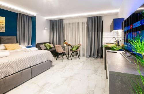 a hotel room with a bed and a dining room at SunnySide luxury suites with free parking and swimming pool in Brela