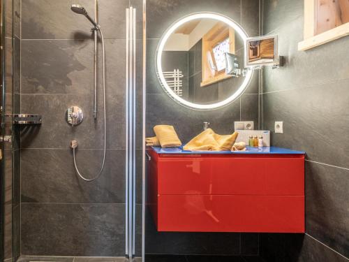 La salle de bains est pourvue d'une armoire rouge et d'une douche. dans l'établissement Luxury Lodge Kaprun Ost A, à Kaprun