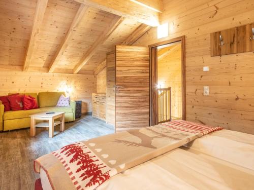 - une chambre dans une cabane en rondins avec un lit et un canapé dans l'établissement Luxury Lodge Kaprun Ost A, à Kaprun