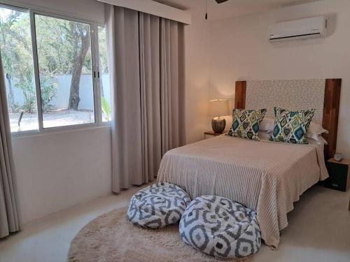 - une chambre avec un lit avec deux ottomanes et une fenêtre dans l'établissement La casa del arbol, à Nosara