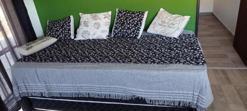 a bed with black and white pillows on it at Abuela Greta in Sierra de la Ventana
