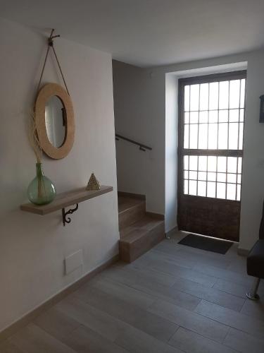 a hallway with a mirror on the wall and a door at EL RINCON DEL ROMERAL in Pegalajar