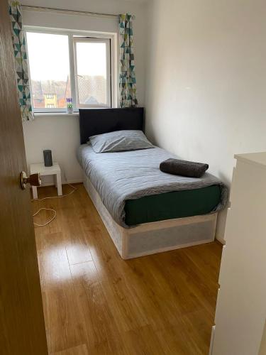 a bedroom with a bed in a room with a window at Cosey Croydon in South Norwood