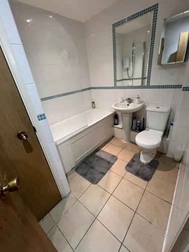 a bathroom with a tub and a toilet and a sink at Cosey Croydon in South Norwood