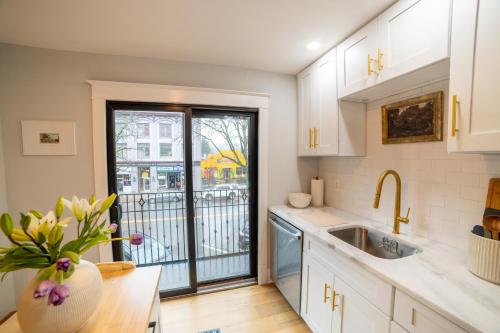 a kitchen with white cabinets and a sink at Prime Location on Main Street in Stroudsburg