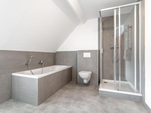 a bathroom with a tub and a toilet and a shower at NRV Top 567 XL in Möderbrugg