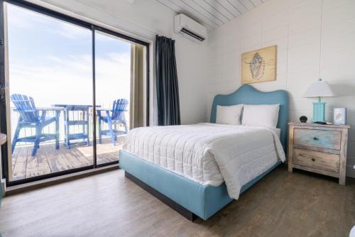 a bedroom with a blue bed and a balcony at Edgewater Lodge in Layton