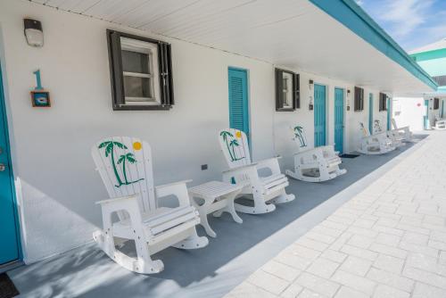 a group of white chairs sitting on the side of a building at Edgewater Lodge in Layton