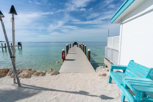 a wooden pier with a blue bench on the beach at Edgewater Lodge in Layton