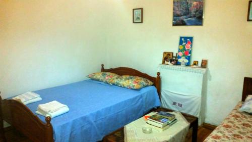 a bedroom with a bed with blue sheets and a table at The Grandfather's Room in Himare