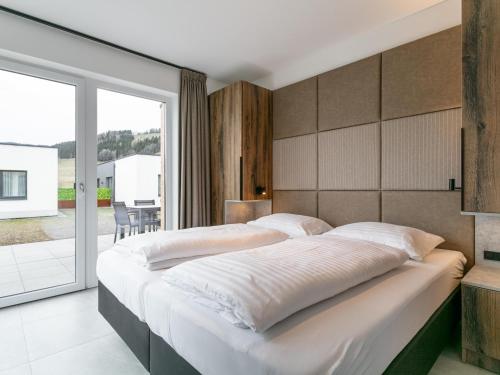 um quarto com uma cama grande e uma janela grande em Grebenzen Lodge 35 em Sankt Lambrecht