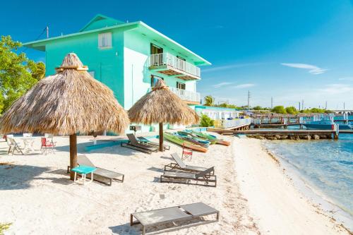a beach with chairs and umbrellas and a building at Edgewater Lodge in Layton
