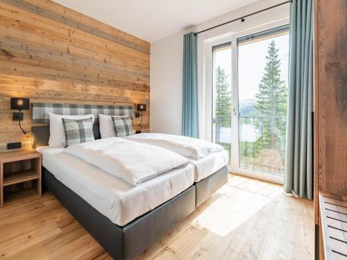 a bedroom with a large bed and a large window at Vista Lodge in Turracher Hohe
