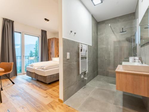 y baño con cama, ducha y lavabo. en Ibex panorama Lodge en Turracher Hohe