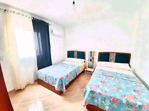 a bedroom with two beds and a window at Golden Beach 2 RasSudr in Al Ḩafāʼir