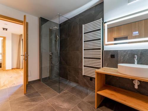 La salle de bains est pourvue d'un lavabo et d'une douche. dans l'établissement Romantik Mountain Chalet, à Turracher Höhe