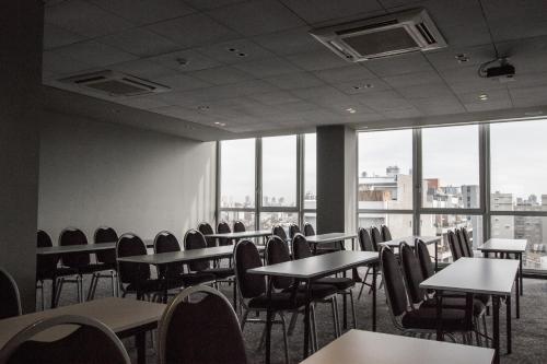 an empty room with tables and chairs and windows at CasaSur Palermo Hotel in Buenos Aires