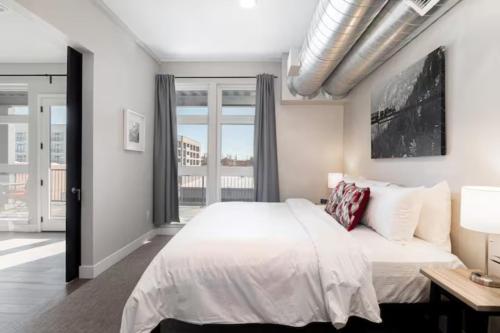 a bedroom with a white bed and a large window at Denver suites rino arts loft - jz vacation rentals in Denver