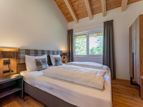duże łóżko w sypialni z oknem w obiekcie Romantik Mountain Chalet w mieście Turracher Hohe