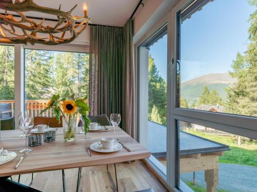 a dining room with a table and a large window at Wanderlust Mountain Chalet in Turracher Hohe