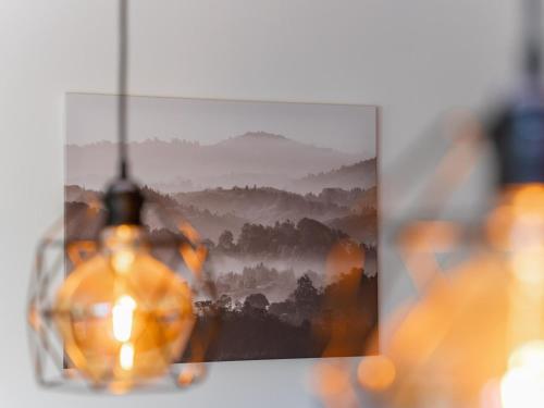a picture of a misty mountain view with a chandelier at Wanderlust Mountain Chalet in Turracher Hohe