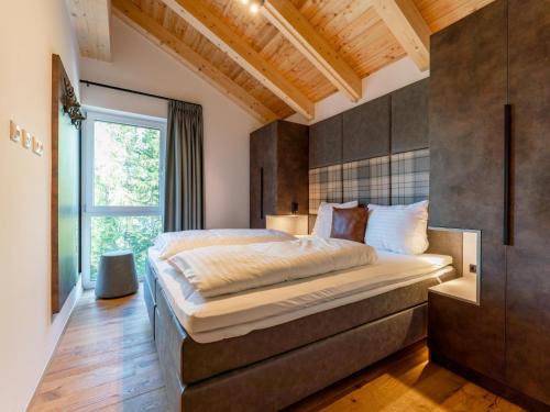 sypialnia z dużym łóżkiem i oknem w obiekcie Wanderlust Mountain Chalet w mieście Turracher Hohe