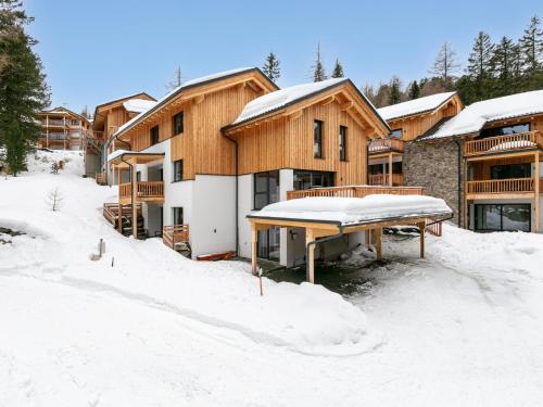 a house in the snow with a picnic table in front at Wanderlust Mountain Chalet in Turracher Hohe