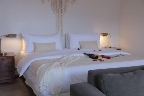 Un dormitorio con una gran cama blanca con flores. en Cabañas Caleta Hueso, en Taltal