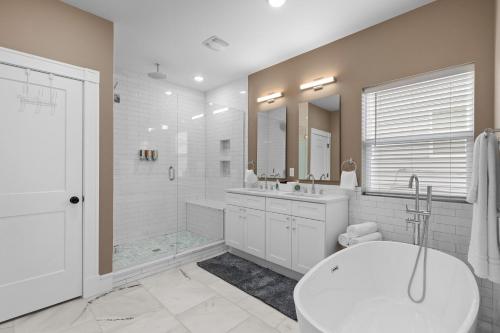 a bathroom with a tub and a toilet and a sink at Spacious family retreat 2 of 2 - jz vacation rentals in Tower Grove