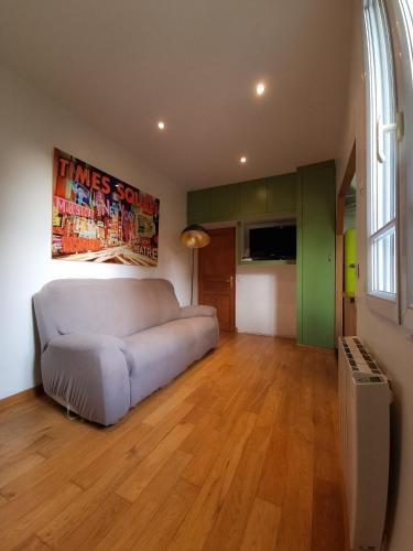 un salon avec un canapé et une grande fenêtre dans l'établissement Appartement élégant calme 10 min de Paris centre, à Clichy