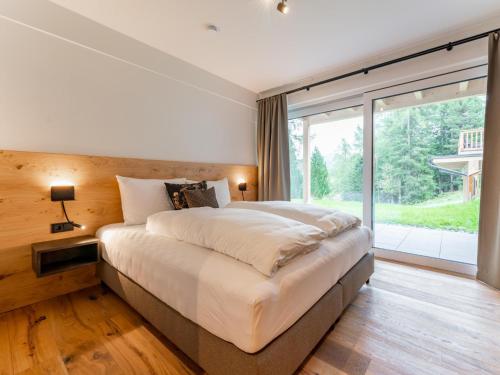 - une chambre avec un grand lit et une grande fenêtre dans l'établissement Silas Mountain Chalet, à Turracher Höhe