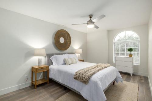een witte slaapkamer met een bed en een spiegel bij 5BR Citrus Family Estate-Sleeps 13-Free Htd Pool-Gameroom in Mesa