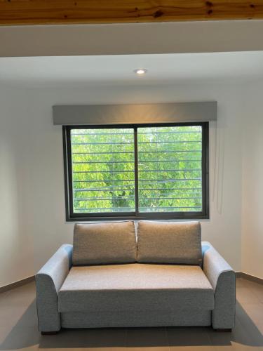 - un canapé dans une chambre avec une grande fenêtre dans l'établissement Lautaro, à San Juan