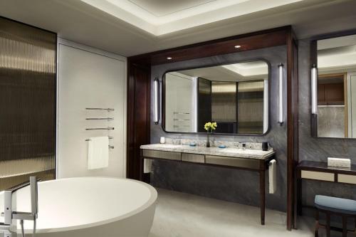 a bathroom with a tub and a large mirror at The St. Regis Qingdao in Qingdao