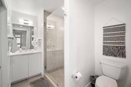a white bathroom with a toilet and a shower at Sweet escape luxury urban cowboy rino arts loft - jz vacations rentals in Denver
